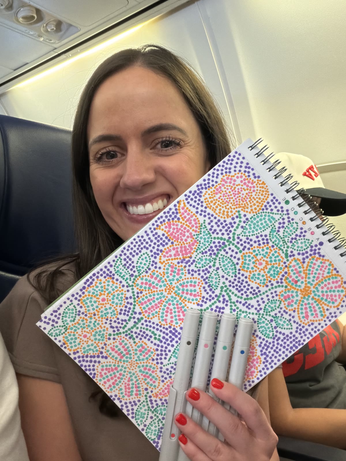 Squeen Bean on a plane with her dot-art flowers